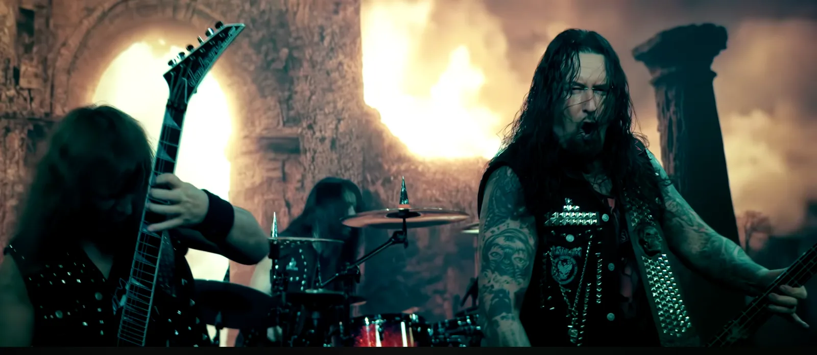 Finaler Frame aus dem DESTRUCTION Musikvideo: die Band spielt vor brennenden Ruinen, produziert per Virtual Production im LED-Studio Erlangen